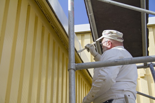 Maalari maalaa taloa