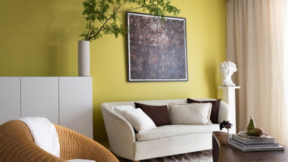 Olohuone, jonka seinä maalattu keltavihreällä Tikkurilan Vuoden värillä Kameleontilla.