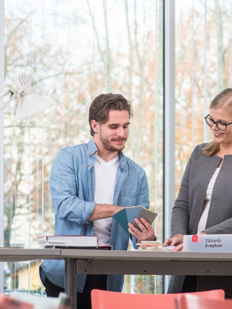 Arkkitehdit tarkastelevat Tikkurilan värimalleja.