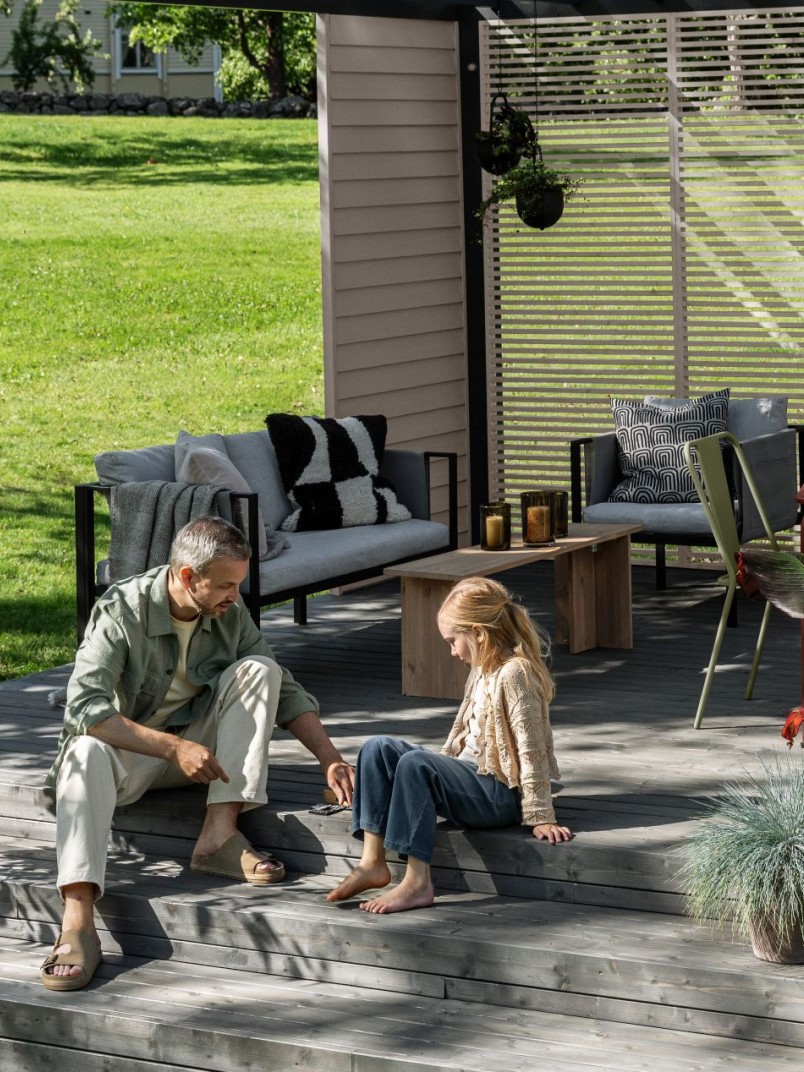 Terassi ja patio, jossa isä ja lapsi nauttimassa kesäpäivästä.