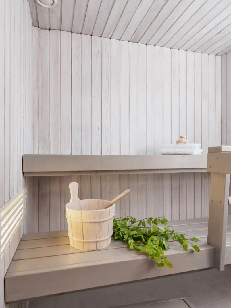 Valkoinen sauna vaaleanharmaalla penkillä