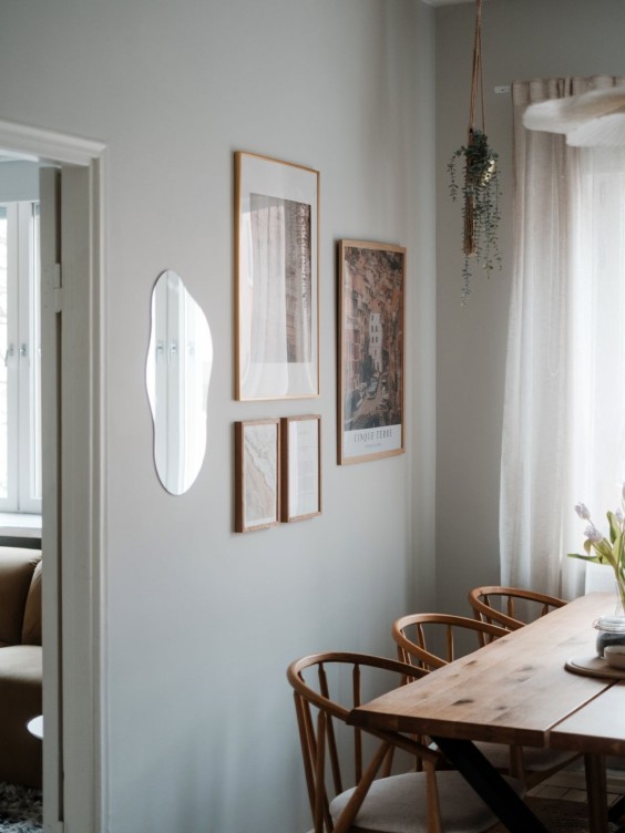 Harmaa keittiön seinä, jossa tauluja ja pieni veistoksellinen peili.