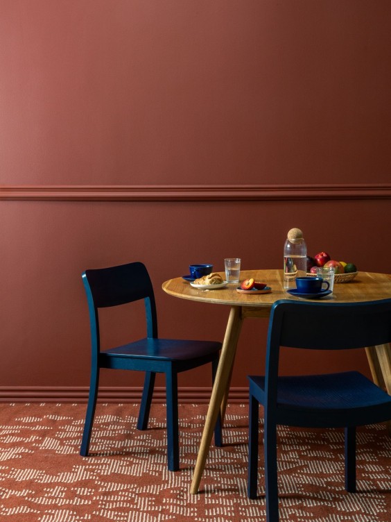 Ruokailutila, jossa siniset tuolit ja punainen seinä.