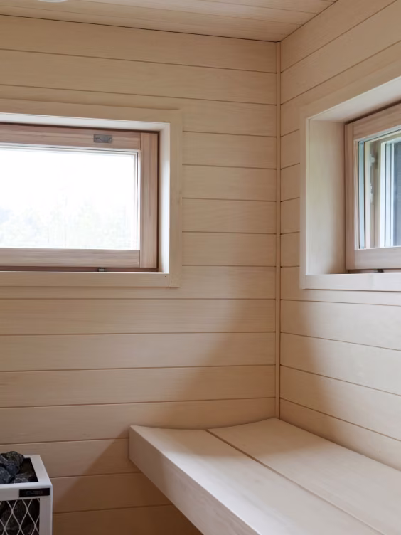 Vaalea moderni sauna leveillä laudepuilla 