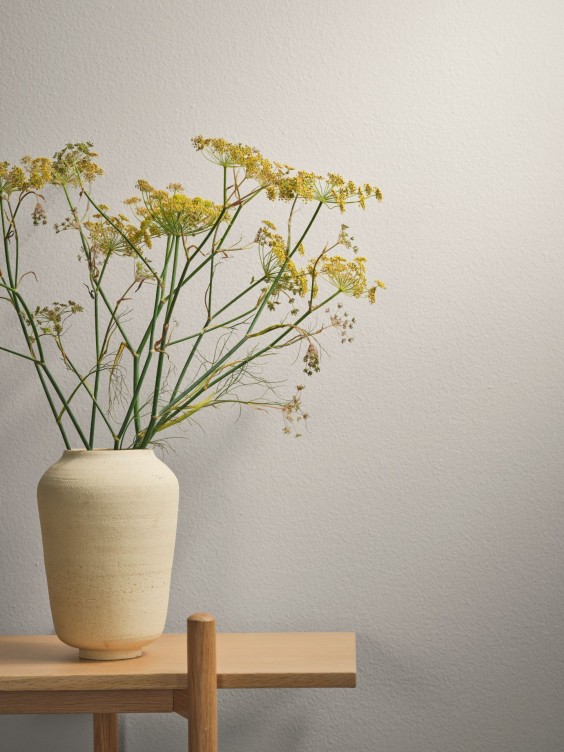 Althara seinällä, edessä maljakko.