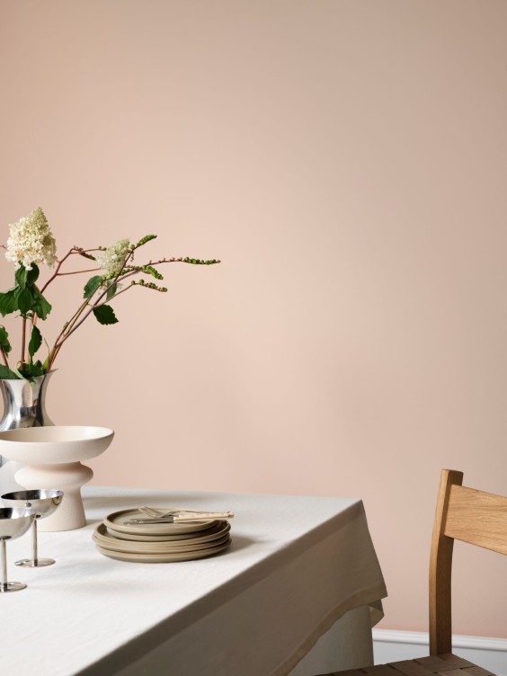 Blossara-maali seinällä. Edessä ruokailutilan pöytä ja tuoli.