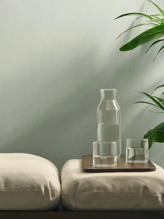 Thalora-sävy seinällä. Edessä daybed ja vihreä huonekasvi.