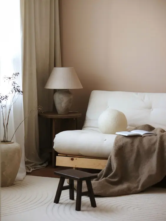 Beige olohuone, jossa levitettävä futon-sohva