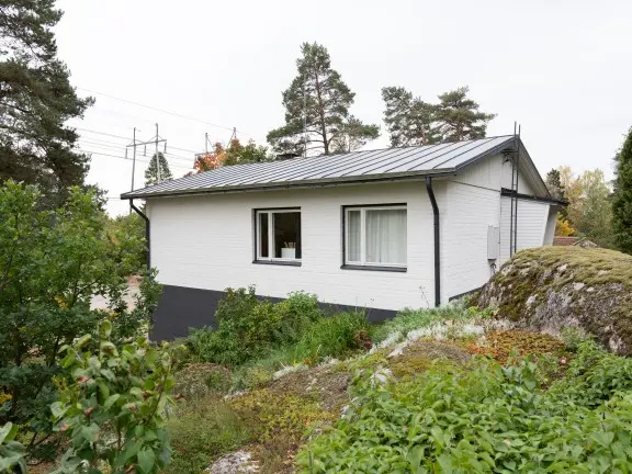 Valkoiseksi maalattu tiilitalo