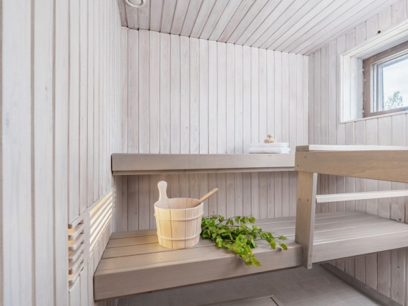 Valkoinen sauna vaaleanharmaalla penkillä