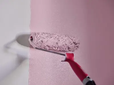 Maalitela maalaa vaaleanpunaista seinään