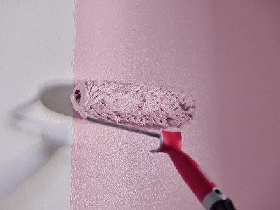 Maalitela maalaa vaaleanpunaista seinään