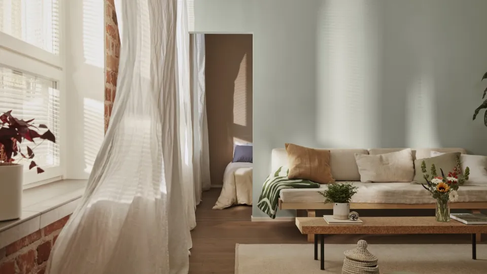 Vaaleanvihreäksi maalattu olohuone