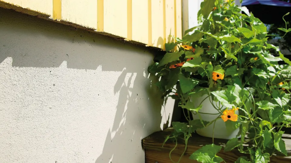 Keltainen puutalo ja harmaa sokkeli