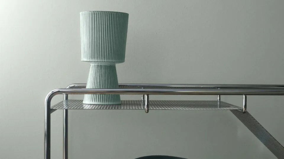 Tarjoiluvaunu vaaleanturkoosia seinää vasten.