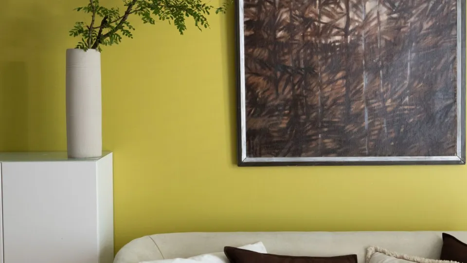 Keltavihreä aurinkoinen olohuoneen seinä.