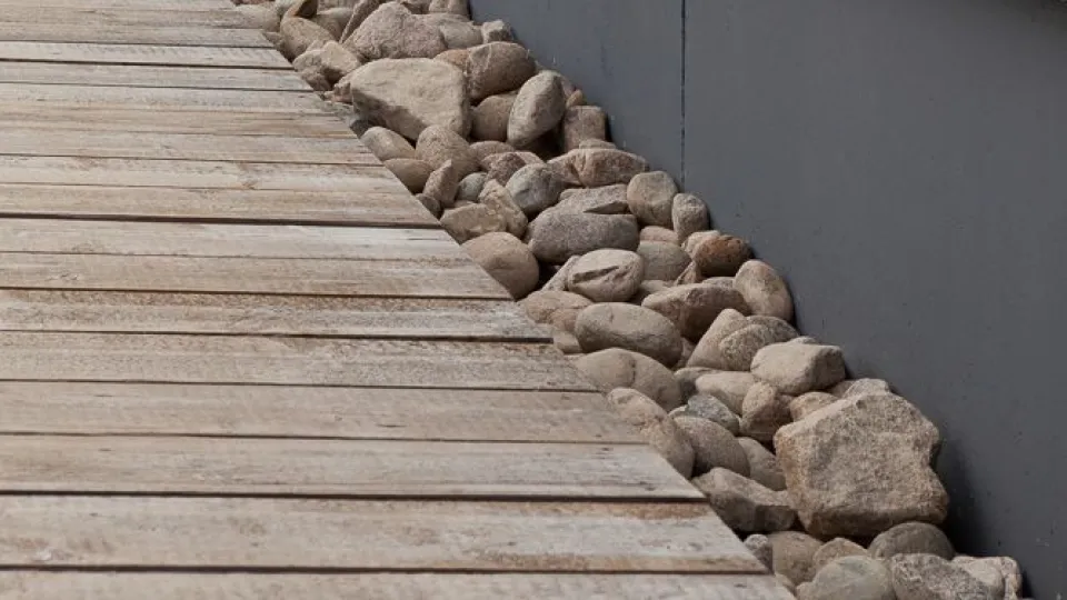 Harmaa sokkeli ja valkoisen talon seinä