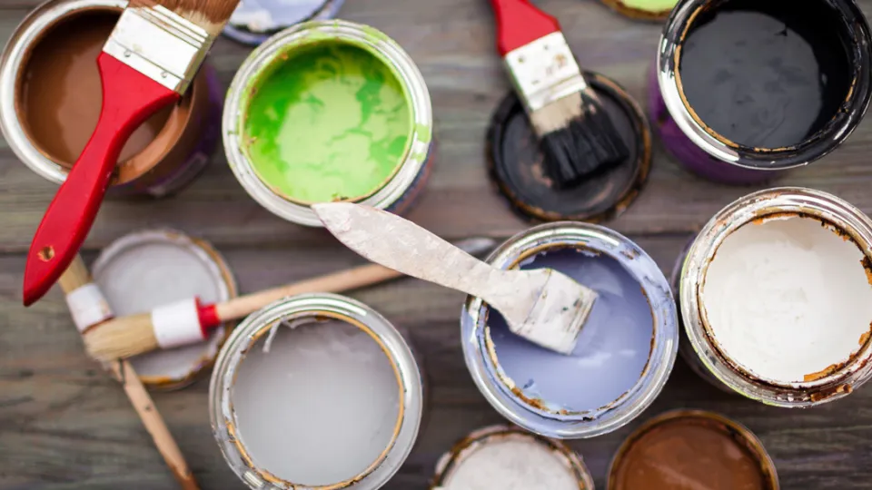 Avonaisia eri värisiä maalipurkkeja ja pensseleitä