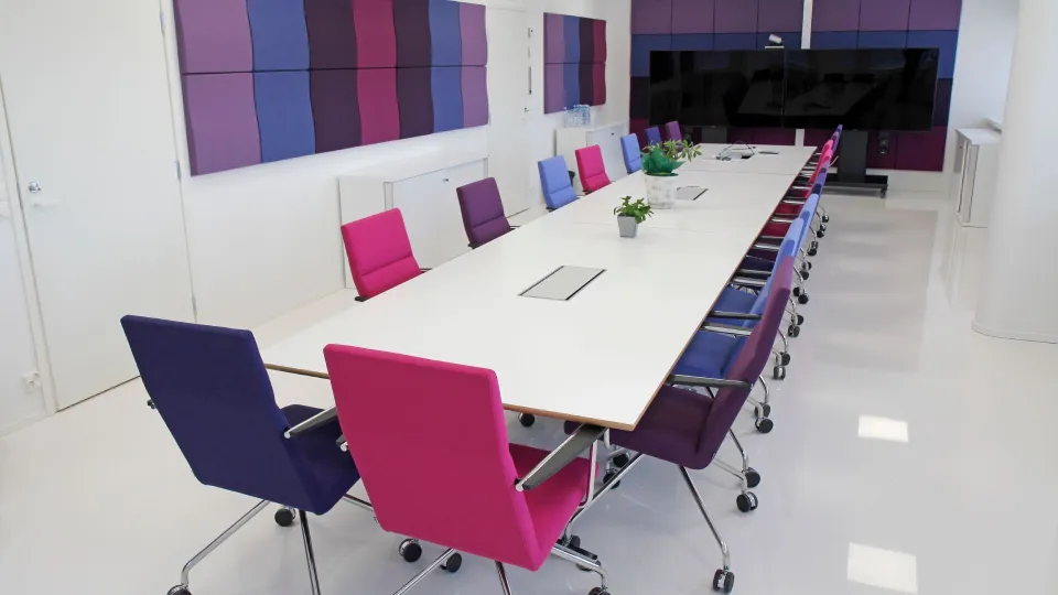 Pitkä neuvottelupöytä toimistotilassa, jonka lattia on pinnoitettu polyuretaanipinnoitteella. 