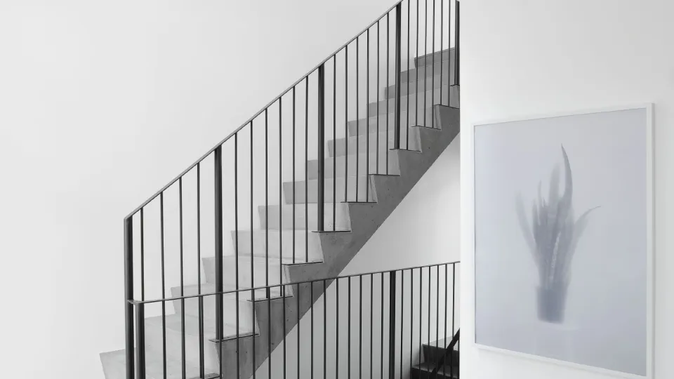 Omakotitalon valkoiset sisäseinät ja portaikko