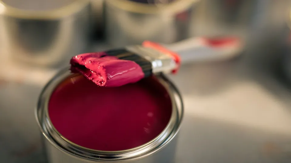 Punaista maalia maalipurkissa ja pensseli