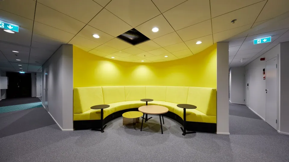 Keltaiseksi maalattu tehosteseinä toimistotilassa.