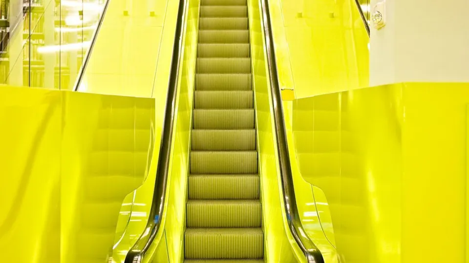 Keltaisella maalattu liukuportaiden käytävä