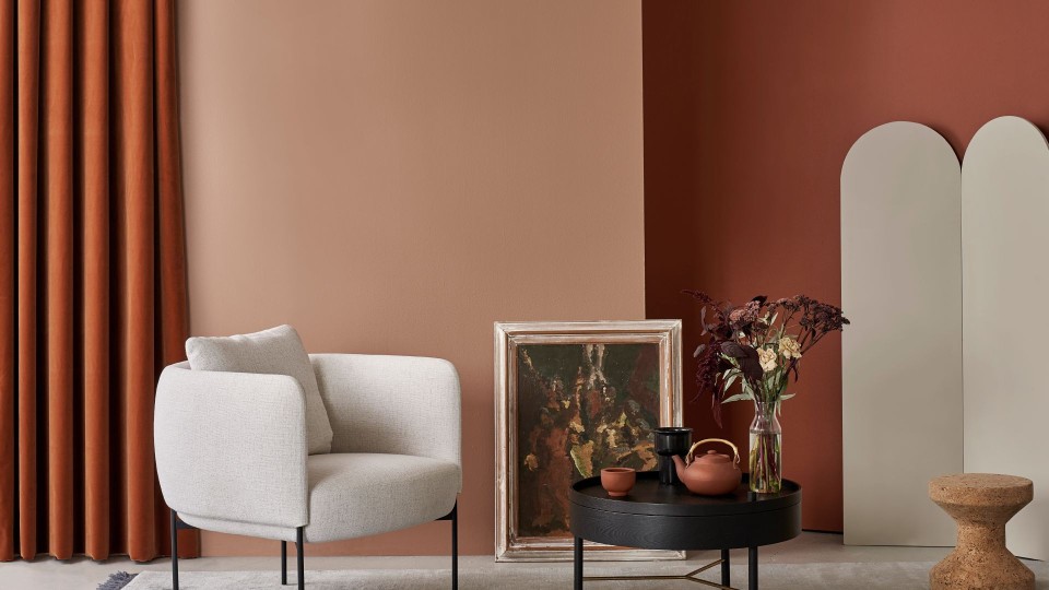 Tyylikäs olohuone vaaleanruskealla seinällä ja tummalla terrakotan sävyllä