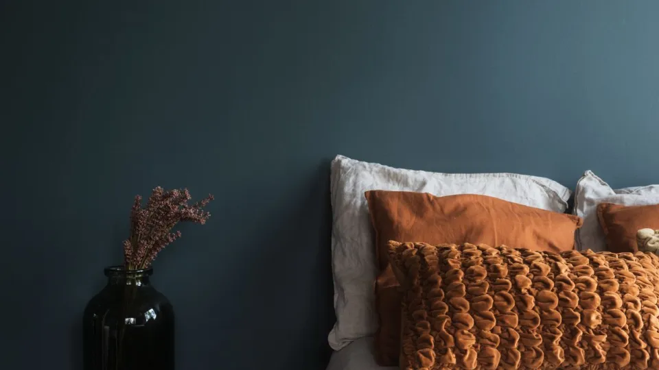 Petroolinsinisellä maalattu tunnelmallinen makuuhuone.