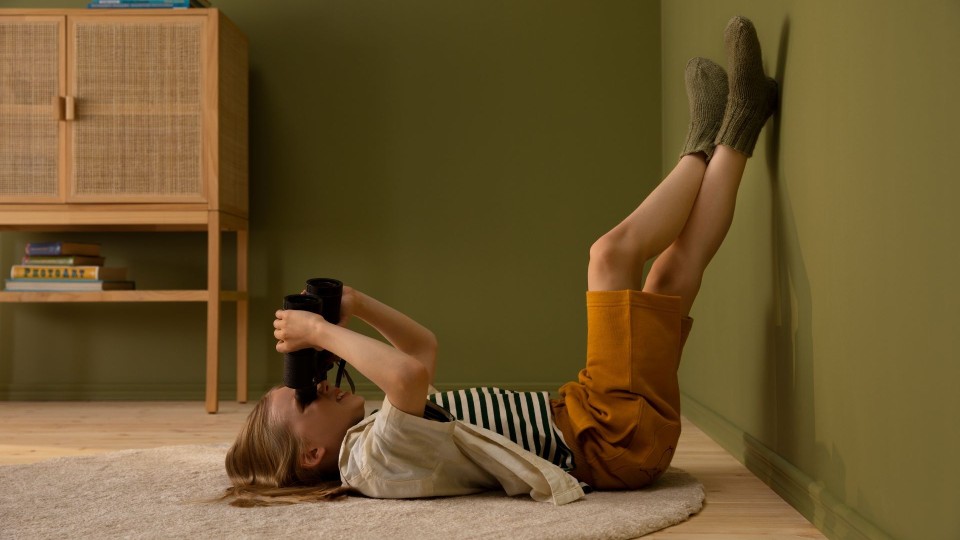 Lapsi makaamassa lastenhuoneen lattialla, jossa on vihreät seinät