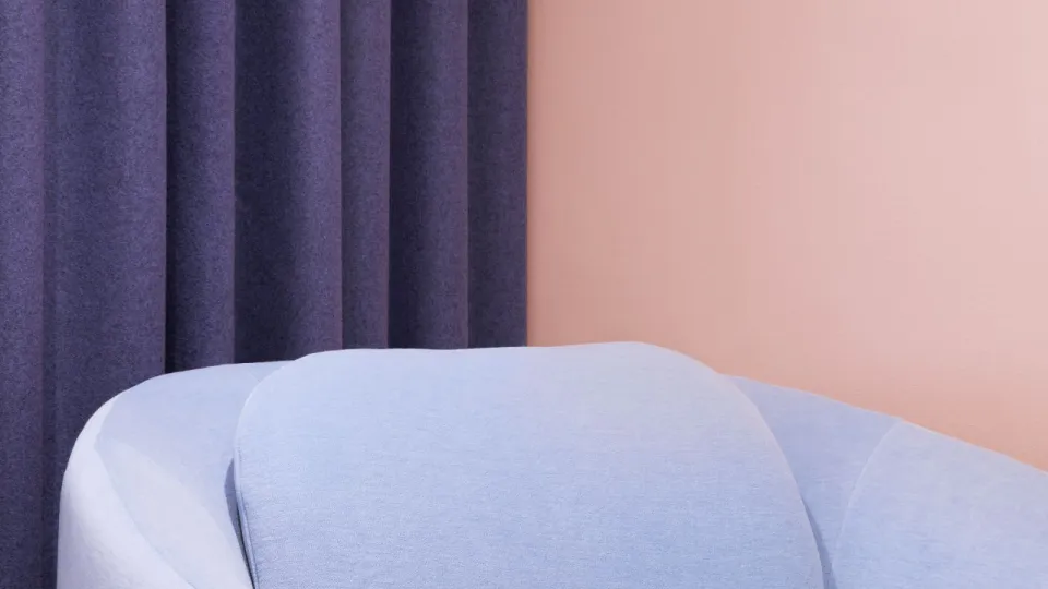 soft peach colour background wall with pastel blue sofa on front