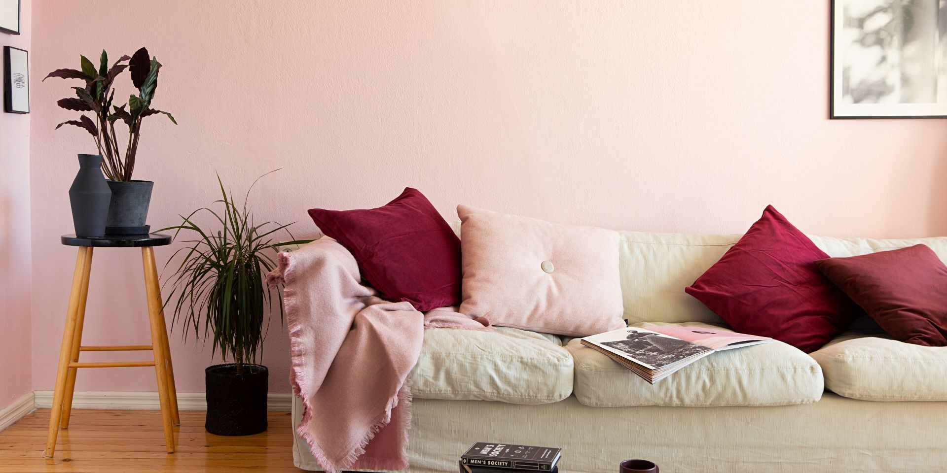 Vaaleanpunaiseksi maalattu olohuone ja vaalea sohva