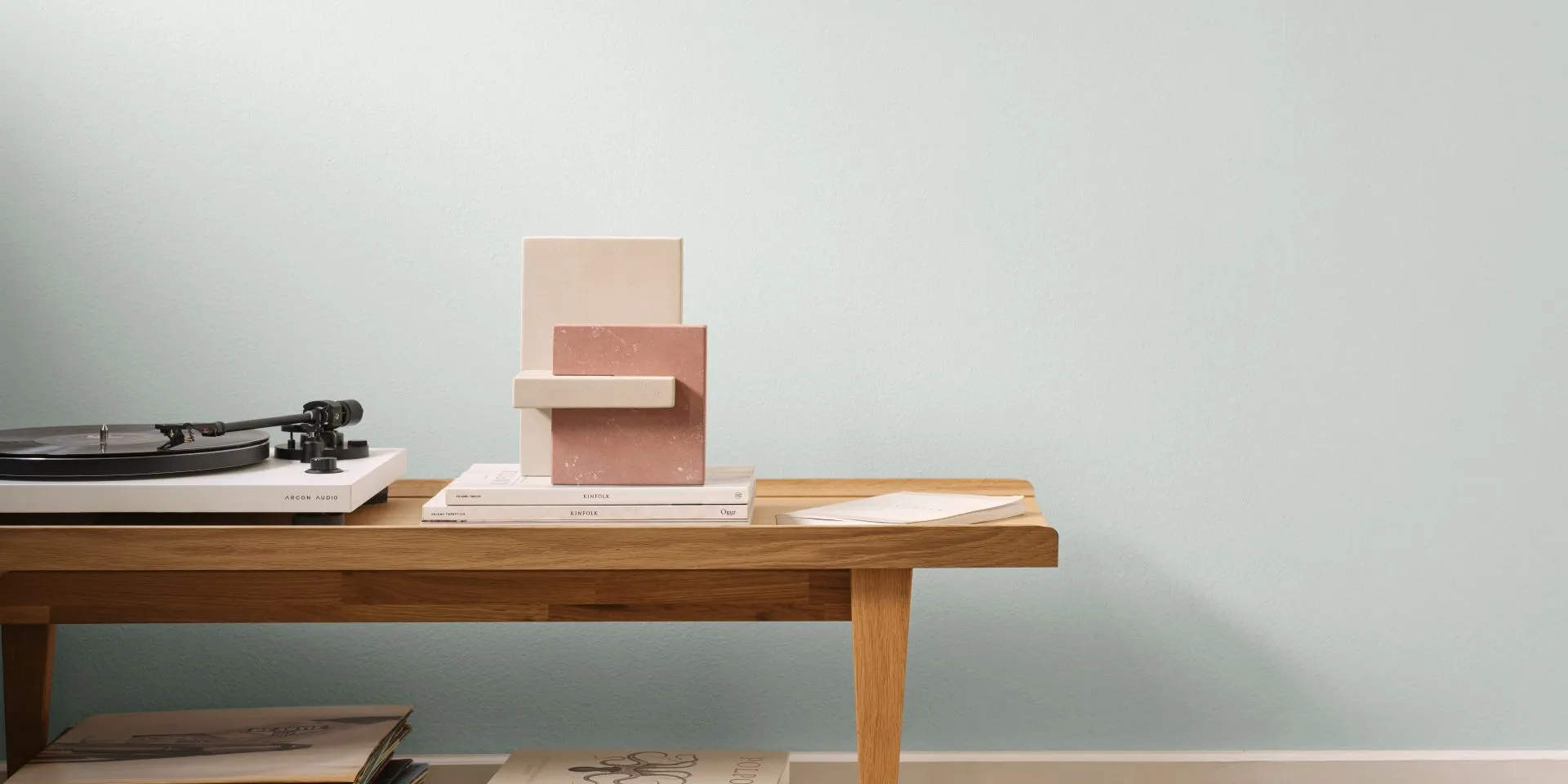 Mute Mistara -sävy seinällä. Edessä pöytä, vinyylisoitin ja levy- ja kirjapinoja.