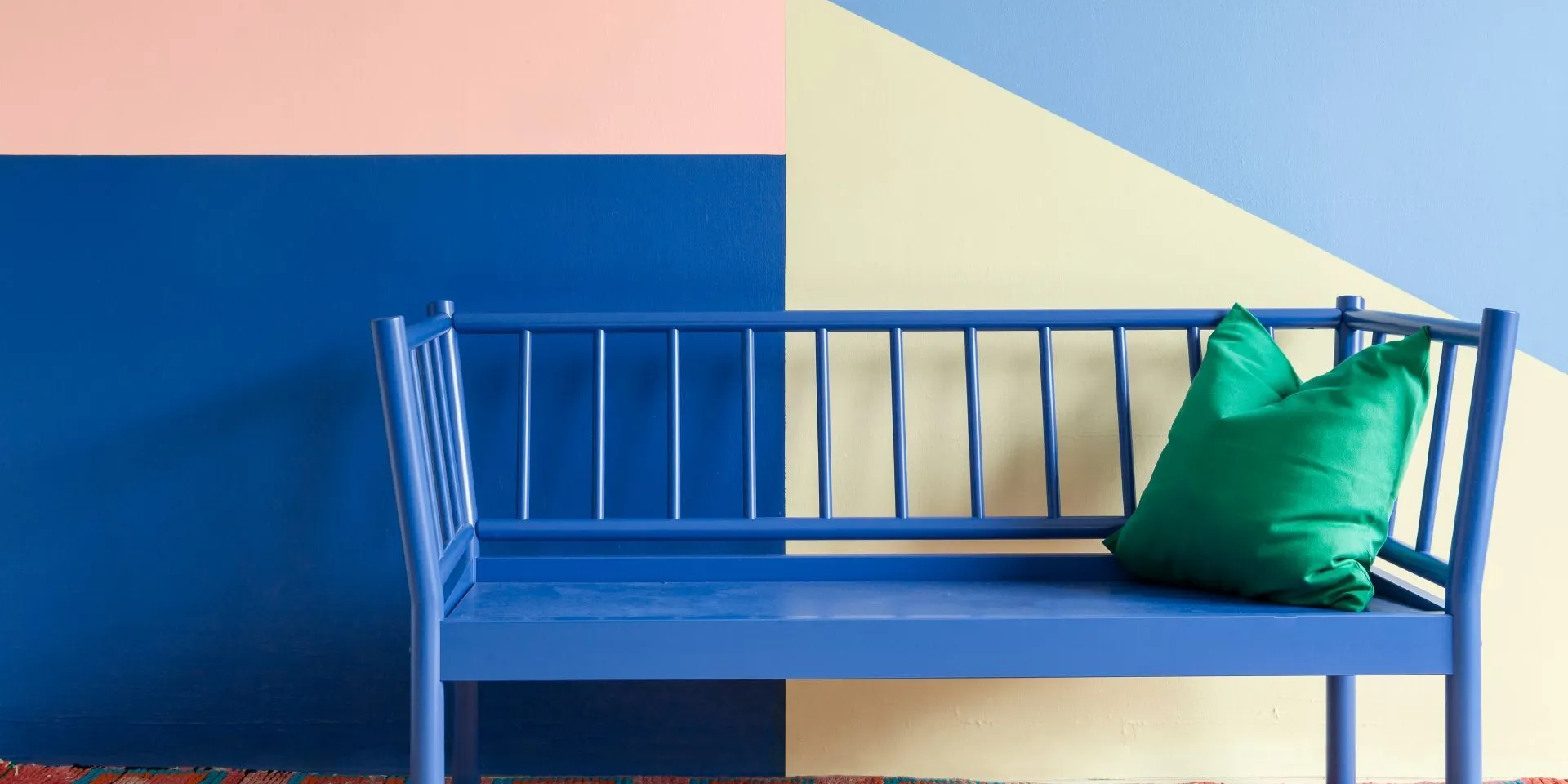 Monivärinen seinä ja sähkönsininen sohva