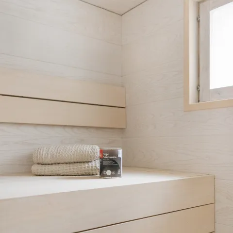 Vaalea moderni sauna, joka on vahattu valkoisella Supi Saunavahalla