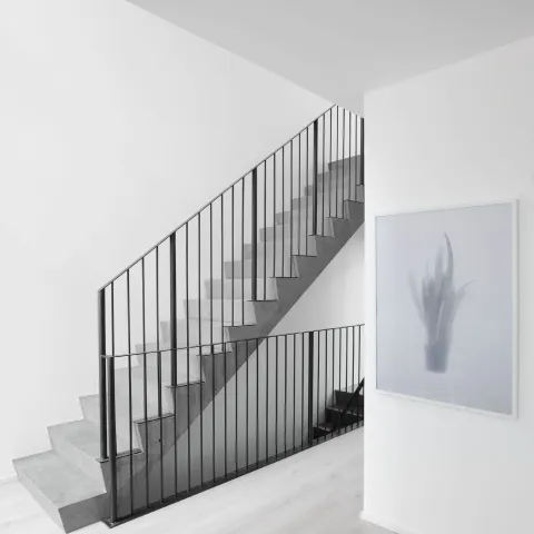 Omakotitalon valkoiset sisäseinät ja portaikko