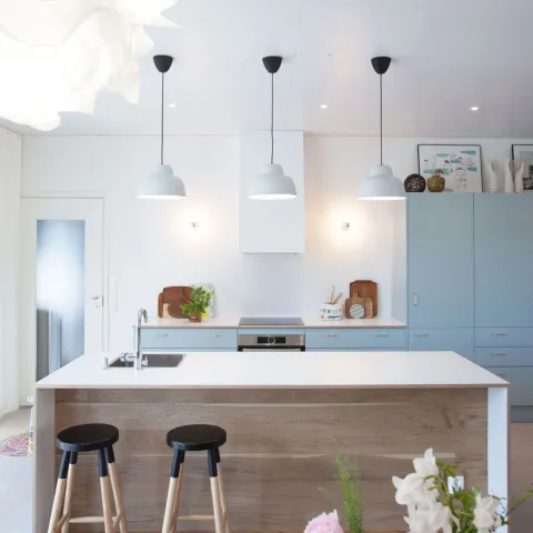 Valkoinen ruokailutila vaaleansinisillä kaapeilla