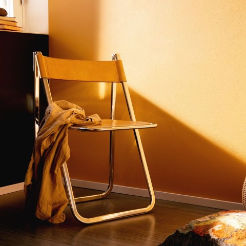Olohuone, jossa keltainen seinä ja keltaiseksi maalattu tuoli