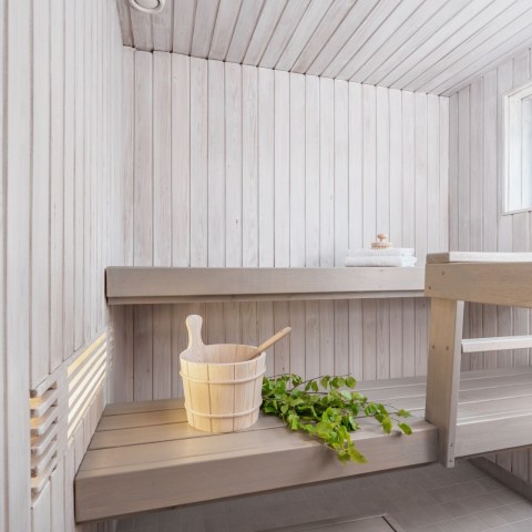 Valkoinen sauna vaaleanharmaalla penkillä