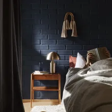 Tummansininen tiiliseinä makuuhuoneessa