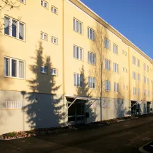 Vaaleankeltainen kiviainesjulkisivu kerrostalossa.