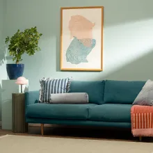 Turkoosi sohva olohuoneessa, vihreä seinä.