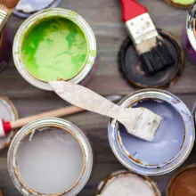 Avonaisia eri värisiä maalipurkkeja ja pensseleitä