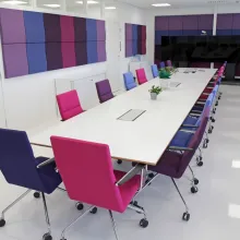 Pitkä neuvottelupöytä toimistotilassa, jonka lattia on pinnoitettu polyuretaanipinnoitteella. 