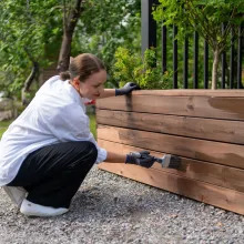 Nainen maalaa kasvatuslaatikkoa