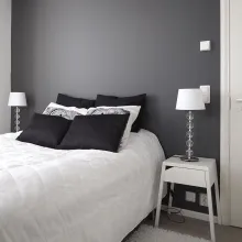Tummanharmaa makuuhuoneen seinä