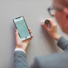 Nainen mittaa seinäväriä Tikkurilan Color Reader värimittarilla