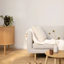 vaaleanharmaa sohva ja puiset kalusteet olohuoneessa