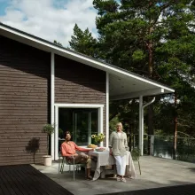 Mies ja nainen ruskean talon terassilla