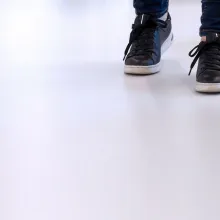 Henkilö kävelee Temafloor polyuretaanilattiapinnoitetulla lattialla. 